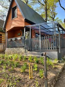 ein Haus mit einer Veranda und einem Zaun davor in der Unterkunft Makkocska Vendégház in Noszvaj