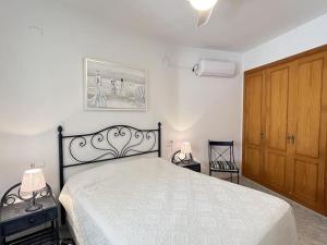 1 dormitorio con 1 cama y puerta de madera en Villa Bassetes By El Conserje, en Denia