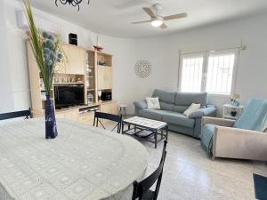 uma sala de estar com uma mesa e um sofá em Villa Bassetes By El Conserje em Denia
