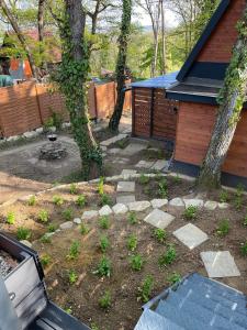 a garden with a tree and a bench in front of a house at Makkocska Vendégház in Noszvaj