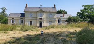 an old house in the middle of a field at Ancien relais de chasse à 35 min du Circuit 24h du Mans in Le Lude