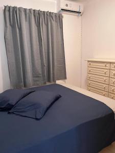 a bedroom with a blue bed and a window at Wave Maze in Vila do Maio
