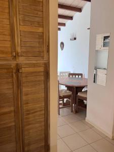 uma cozinha e uma sala de jantar com uma porta de madeira em Wave Maze na Vila do Maio