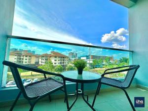 a table and two chairs on a balcony with a window at Seasons Luxury Apartment By RR JBcity in Johor Bahru