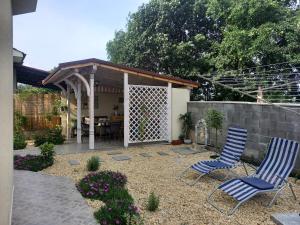 eine Terrasse mit 2 Stühlen und einer Pergola in der Unterkunft вила ФЛОРА in Tschernomorez