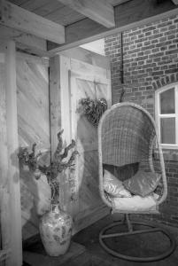 a wicker chair and a vase in a room at Bed en Box 3610 in Oirschot