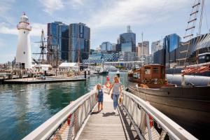 a group of people walking on a dock near the water at Metro Apartments on King in Sydney