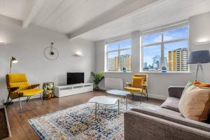 a living room with a couch and a tv at 3 bed apartment near Old Street and City of London in London