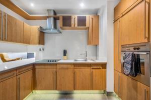 a kitchen with wooden cabinets and a sink at 3 bed apartment near Old Street and City of London in London