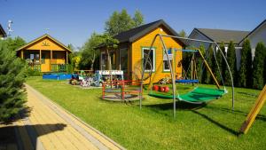 - une aire de jeux dans une cour avec une maison dans l'établissement Czerwone Korale, à Sarbinowo