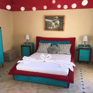 een slaapkamer met een bed met een rood hoofdeinde bij Casa Montegri 1 in Hal Ghaxiak
