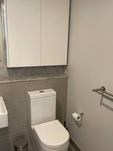 baño con aseo blanco y armario en Lovely CBD two bedroom apartment free parking en Canberra