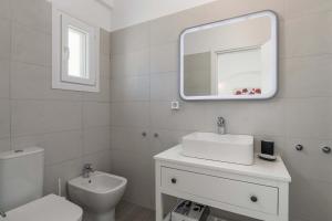 a bathroom with a sink and a toilet and a mirror at Sunset Village 1 in Paleochori