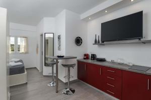 a kitchen with a bar and a tv on the wall at Sunset Village 1 in Paleochori