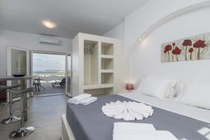 a bedroom with a bed and a table and a balcony at Sunset Village 1 in Paleochori
