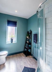 baño con ducha y aseo y ventana en Cobden House - 5 Bed, 5 En-suite en Farnley