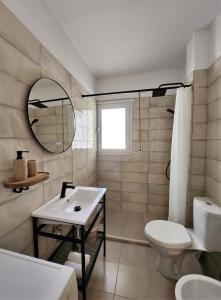 een badkamer met een wastafel, een toilet en een spiegel bij ELISOS Studio Apartment with swimming pool in Vlorë