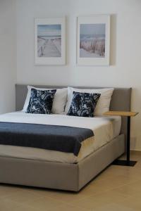 een bed in een kamer met twee foto's aan de muur bij ELISOS Studio Apartment with swimming pool in Vlorë