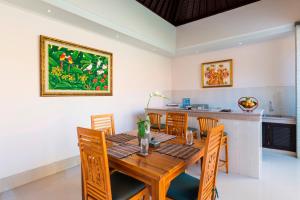 a dining room with a wooden table and chairs at Kubal Villa and Living Seminyak in Canggu