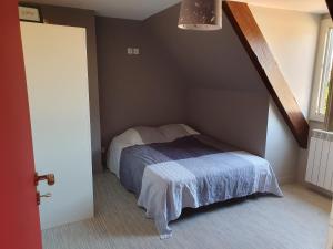ein Schlafzimmer mit einem Bett in der Ecke eines Zimmers in der Unterkunft La ferme du Riau in Aurouer