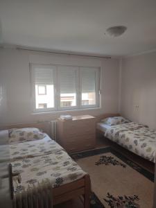 een slaapkamer met 2 aparte bedden en een raam bij Apartman 1 in Foča