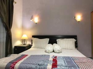 1 dormitorio con 1 cama grande con sábanas y almohadas blancas en Mitra@Guesthouse b29, en Batam Centre