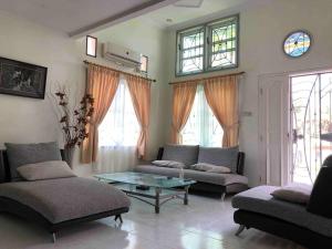 - un salon avec deux canapés et une table dans l'établissement Mitra@Guesthouse b29, à Batam Center