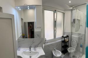 Un baño con lavabo, inodoro y espejo. en Dalla Laretta di fronte all Acquario di Genova, en Génova 19 fotos más