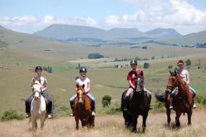 a group of people riding horses in a field at Lowestoffe Country Lodge - Trout in Hogsback