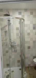 La salle de bains est pourvue d'une douche avec une porte en verre. dans l'établissement Casa Ageitos, à Vimianzo