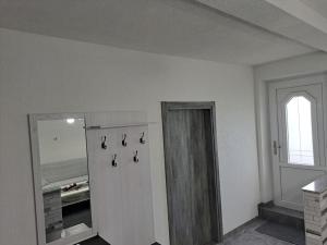 Cette chambre blanche dispose d'une porte et d'une fenêtre. dans l'établissement Apartman Ivo, à Livno