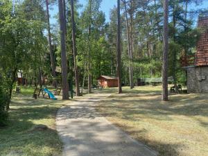 un sendero en un parque con parque infantil y árboles en Domki Pod Sosnami, en Stegna