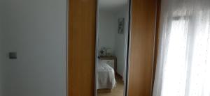 espejo en una habitación con cama en un dormitorio en Casa Ageitos, en Vimianzo