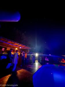 um grupo de pessoas em pé em uma festa à noite em Pousada Espaço Naves LunaZen em Alto Paraíso de Goiás