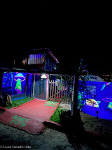 uma casa iluminada à noite com luzes azuis em Pousada Espaço Naves LunaZen em Alto Paraíso de Goiás