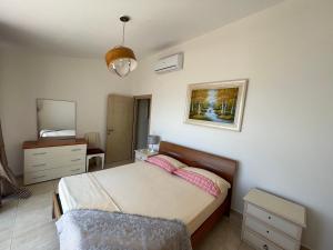 1 dormitorio con cama, tocador y espejo en Apartments Wonderful bay, en Sarandë