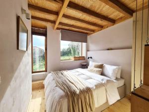 a bedroom with a large bed and two windows at Hidden gem of 1900, 7km from sea in Potamós