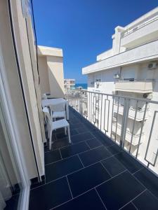 - un balcon avec une table et des chaises dans un bâtiment dans l'établissement A&T Apartments, à Durrës