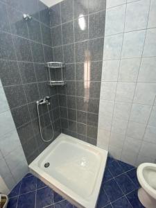 La salle de bains est pourvue d'une douche, d'un lavabo et de toilettes. dans l'établissement A&T Apartments, à Durrës