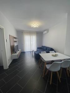 - un salon avec une table et un canapé bleu dans l'établissement A&T Apartments, à Durrës
