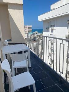 d'un balcon avec une table et des chaises donnant sur l'océan. dans l'établissement A&T Apartments, à Durrës