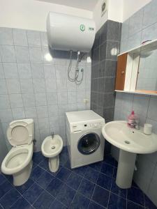 La salle de bains est pourvue de toilettes, d'un lavabo et d'un lave-linge. dans l'établissement A&T Apartments, à Durrës