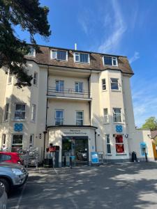 a large white building with a car parked in front of it at Flat 12 Palm Court in Bournemouth