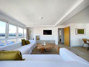 a living room with a white couch and a table at Luxury City Penthouse with views in Belfast