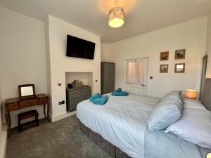 a bedroom with two beds and a desk and a television at The Snug at Ascerton in Sidmouth