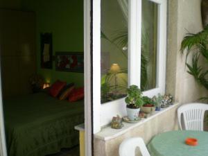 a bedroom with a bed and a window with plants at Orizzonte B&B in Cefalù