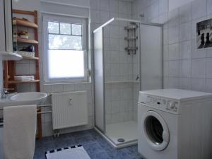 een badkamer met een wasmachine en een wastafel bij Ferienwohnung H 25 "Tausendschön" in Graal-Müritz