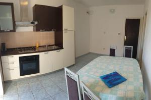 a small kitchen with a bed and a table in it at Seaside Stay Rošić 2 in Ivan Dolac +20 photos