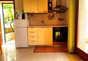 eine Küche mit gelben Schränken und einem weißen Kühlschrank in der Unterkunft Apartments Iris in Korčula