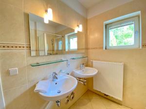 a bathroom with two sinks and a mirror at Villa Jasmin - Ferienwohnung 7 in Heringsdorf